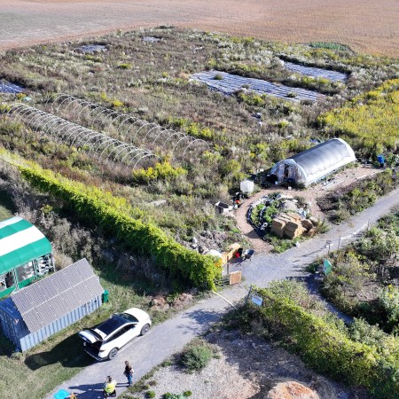 overhead view of the 2 acre training farm taken from the SW showing the greenhouse, hoophouse and some tarped large plots